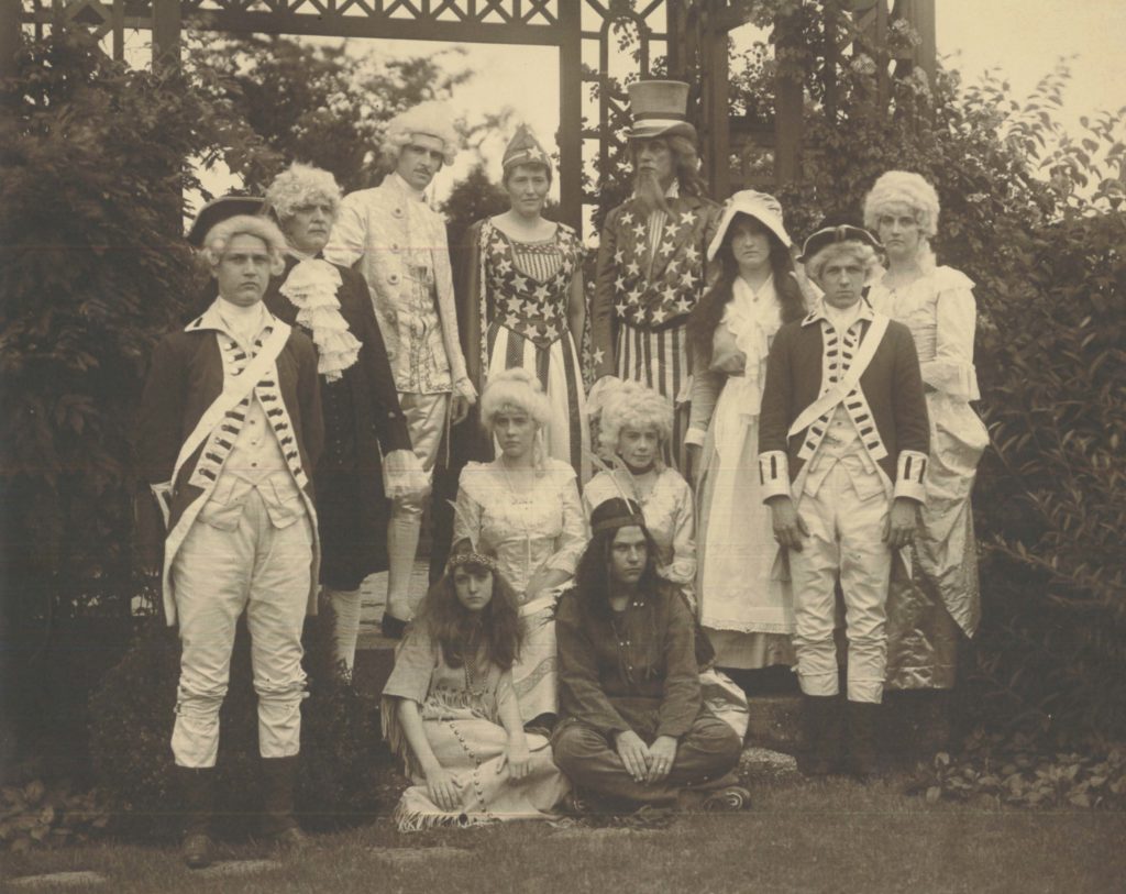 This image depicts 12 people dressed in confederate/patriotic attire. Most are standing.