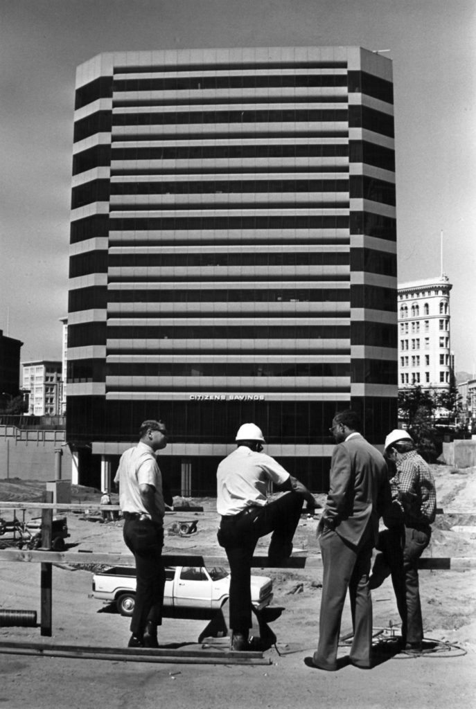 Black and white image of men of Trans-Bay Engineers, standing in front of a commercial building in Oakland, California.