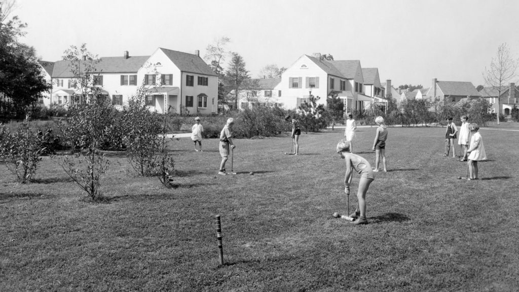 Black and white photo of community members playing Croquet.